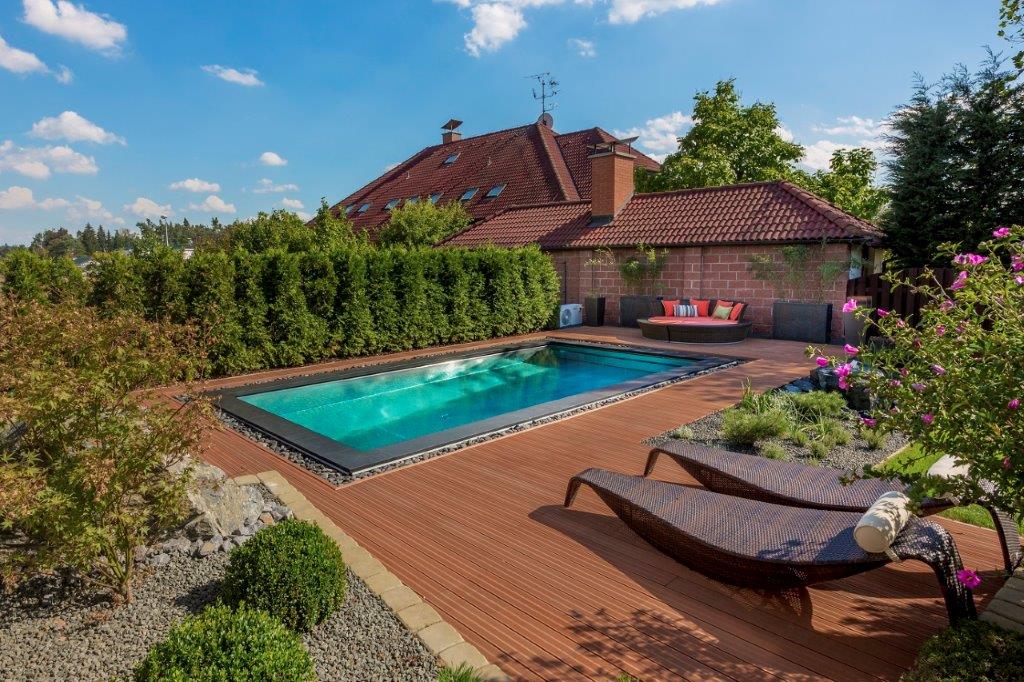 Edelstahl-Schwimmbecken mit einer mit Steinen überdeckten Überlaufrinne